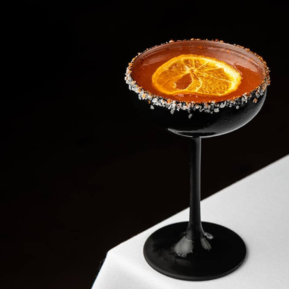 Cocktail with dried orange and crystallized rim